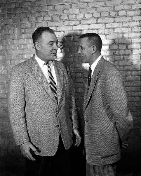 George Lamphear (left), University of Wisconsin Freshman football coach, talks with Bob Kloss, LaCrosse Central High School basketball coach.