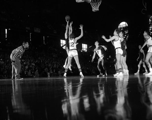 Sam Anicaife (# 12), West Allis Hale center, attempts to block a shot by an unidentified Spooner player in Friday afternoon's game at the State High School Basketball Tournament.