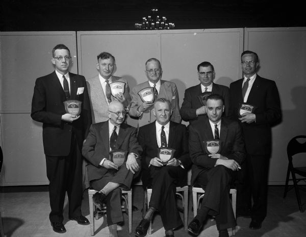Eight representatives of canning factories in Wisconsin were winners of the 1955 Safety Contest and received a plaque decorated with the Green Cross Food Safety symbol.