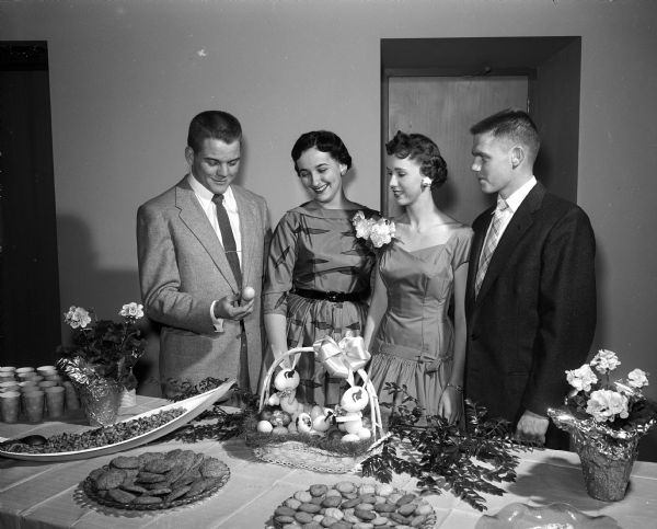 Four classmates and friends from Wisconsin High School admire some of the decorations at a Pre-Easter dancing part held at the Nakoma Golf Club. Left to right are: Robert Patterson, Elaine Bricker, hostess Betsy Strang, and John Coombs.