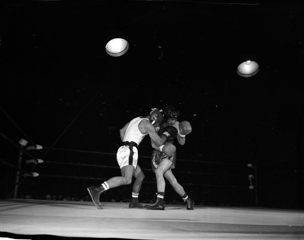 Joji Tomi (left) fights with Ralph Garrow during the match between the University of Wisconsin and the Quantico Marines at the University of Wisconsin-Madison Field House.