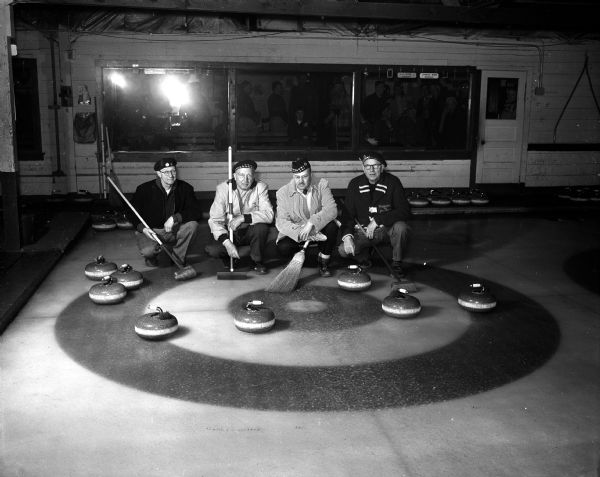 Group portrait of members of the Joe Baer rink after accomplishing a rare feat in Madison Curling Club's bonspiel match. The men include, from left: Elmer Waldvogel, Henry Bruns, Stan Nerdrum, and Skip Joe Baer.