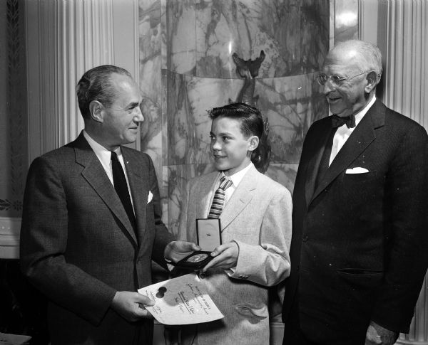 Governor Walter J. Kohler receives the Golden Anniversary Award from two representatives of the Boys' Clubs of America.