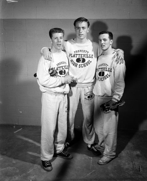 Group portrait of the Platteville High School high hurdle shuttle relay team, winners of their event at the West High School Relays event. Left to right: Jerry Platt, Ted Kramer, and Bob Millman.