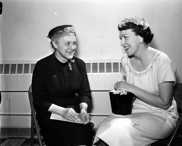 Two women chat during the noon luncheon at the second annual convention of the Madison Diocesan of Catholic Women held at Our Lady Queen of Peace Catholic Church. At left is Mrs. John W. Baumgart of Milwaukee, and at right is Mrs. Paul W. (Virginia) Sergerson, Jr. of Madison.