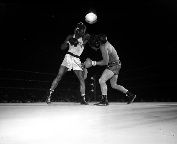 Wisconsin's Orville Pitts throws a left punch at Louisiana State's Malcolm Buhler during the NCAA boxing tournament.