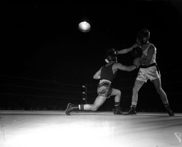 Wisconsin's Dean Plemmons (right) blocks a punch by Washington State's Willard Ira during the NCAA boxing tournament. Plemmons was the first of five Wisconsin Badgers to win 1956 NCAA crowns.