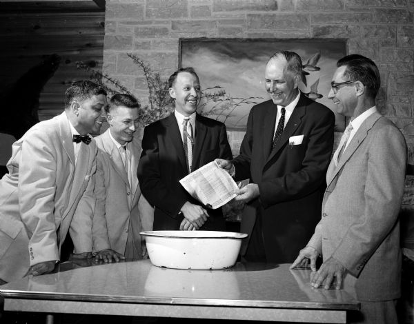 Members of the Blackhawk Ski Club Board of Directors burn the mortgage deed to the Club's 32 acre tract at Tomahawk Ridge hill during a club banquet. Left to right are: Sam LaBarre, Bill Duckwitz, Stan DuRose, Art Jacobson, and Harold (Blue) Schmelzer.
