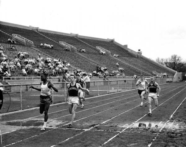 Runners crossing the finish line at the University of Wisconsin vs. Michigan State track meet. Michigan State's Edgar Brabham beat University of Wisconsin's Don Hebein in the 100-yard dash.