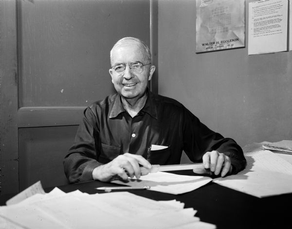 Seated at his desk is Darwin H. Leavitt, statistician at Oscar Mayer & Company. He is also a member of and treasurer for the Philharmonic Chorus. The chorus is celebrating its tenth anniversary.
