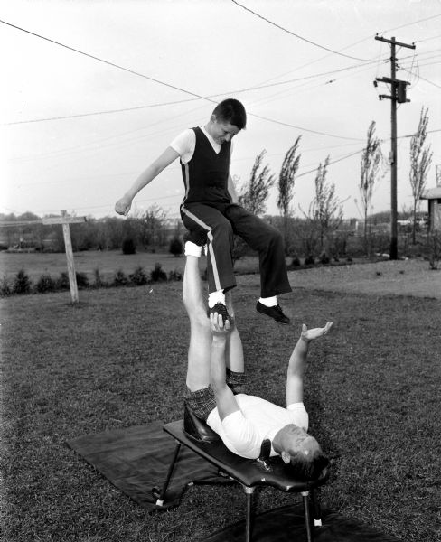 Portrait of George and Peter Bauer, a father and son risley act. Risley is a form of tumbling by one individual while being juggled on the feet of another. George Bauer was a University of Wisconsin physical education assistant professor. Peter is 13-years-old.