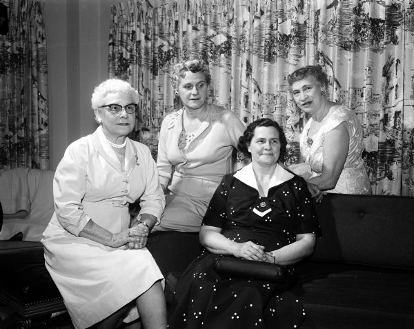 Mrs. Ned Dodge, Lake Mills, program chairman; Eleanor Lee, publicity chairman; Isabel Thompson, transportation chairman and Mrs. Sumner Timm, Eau Claire, gather during a party at the Hotel Loraine.