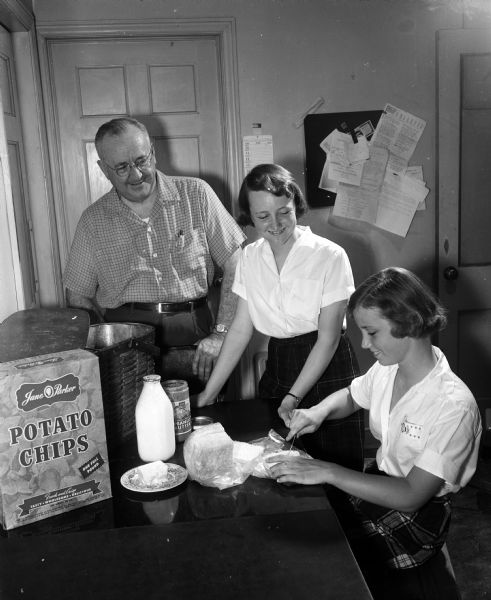 R. Glenn Weiss watches as his two oldest daughters, Caroline, 15, and Christine, 13, make sandwiches for a family picnic.