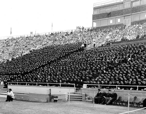 Students are seated in the stands at University of Wisconsin graduation ceremony.