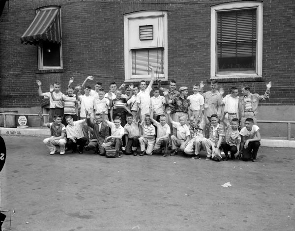 Thirty carrier boys for Madison Newspapers wave goodbye before leaving on a train for a four-day vacation trip to Washington D.C. These boys won the trip by ranking high in the annual subscription contest. The group included 11 Madison boys and 19 area boys.