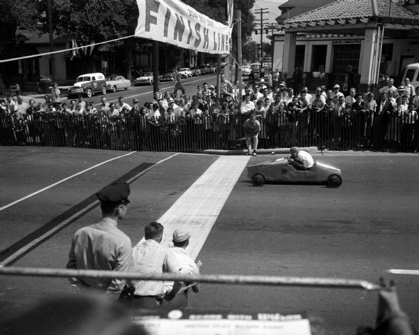Judges Jim Green and Bob Reger view the race from the East Washington Avenue finish line. Ozzie Johnson and Dick Meyer were other judges. Most cars finished the course in 26 1/2 seconds.