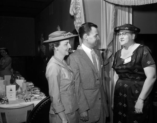 Edith Brandt(?), president of the Wisconsin chapter of the American Business Women's Association, greets a couple at the association's regional brunch at the Edgewater Hotel.
