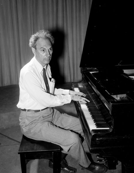 Arthur Roberts, Professor of Physics at Rochester University, demonstrates his other passion in life while seated at a piano. He is in Madison working on a science fiction "space" opera.