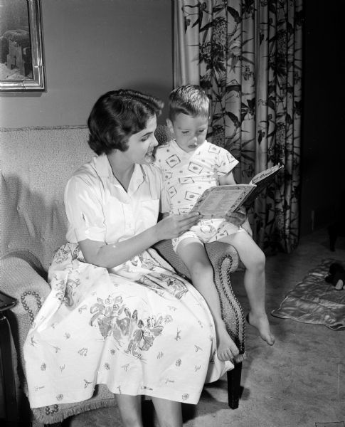 Babysitter Linda Taylor, a ninth grade student at West High School, reads a bedtime story to Brendan Charlton.
