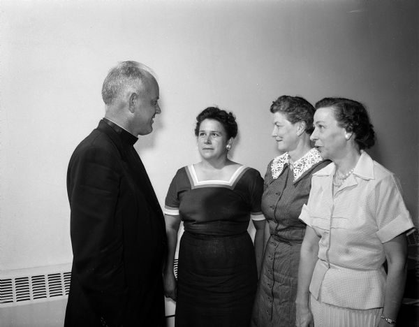Three officers of the Madison Diocesan Council of Catholic Women board chat with Rev. E.G. Brill, Jefferson. Left to right:  Rev. Brill; Kathryn Bruening, diocesan president; Bernadette Byrne, treasurer; and Mrs. Merrald H. Haag, Jefferson, secretary.