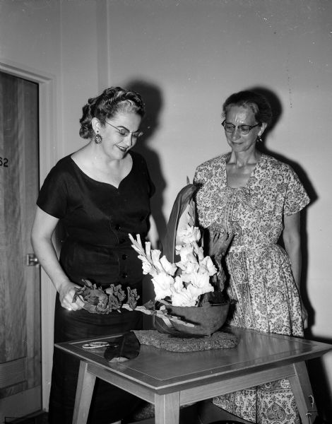 Mrs. Ralph De Woody and Colette Wiffler admiring a floral arrangement at the gladiolus show at the University of Wisconsin-Madison Field House.