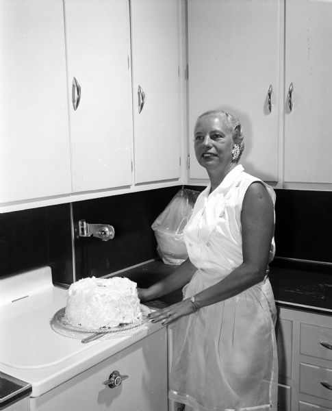 Virginia Hall displays her angel food cake. Part of photo spread for the <i>Wisconsin State Journal</i> Centennial Cookbook Contest.