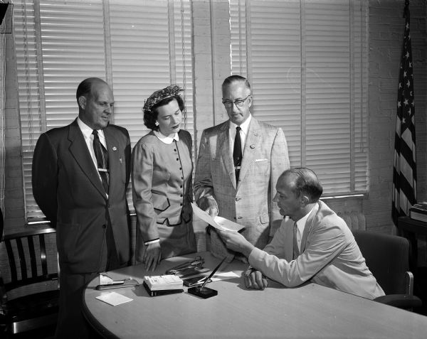Three members of Beautiful Madison, Inc. give a letter to Mayor Ivan Nestingen (seated at desk) requesting a city ordinance against littering in Madison streets. Left to right: Glenn Groesbeck, secretary; Elizabeth Runge, member of the board of directors; and Dr. Arnold Jackson, president.