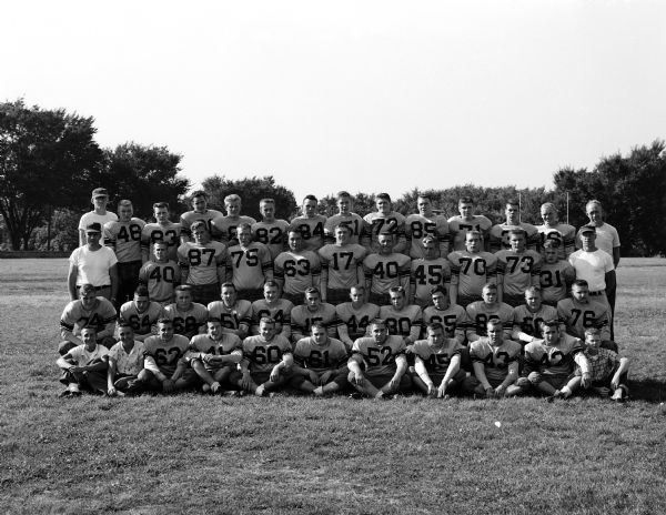 Group portrait of the West High School football team in uniform with managers and coaches.