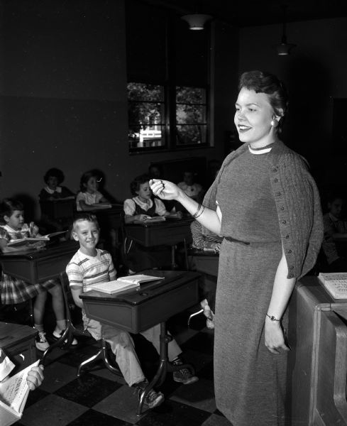 Miss Dorothy Mydland, 409 South Randall Avenue, is the new music teacher at Washington School. A few of her students are shown in the background.