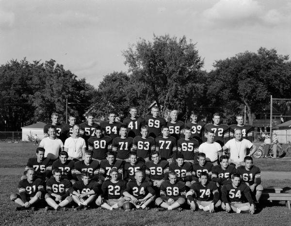 Outdoor group portrait of the Madison East High School football team.