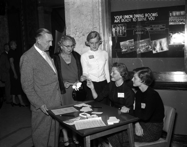 Wanda Wordell, of Brillion (center) starts her career as a freshman co-ed as she registers at a reception for incoming freshmen held in the Memorial Union. On the left are her parents, Mr. and Mrs. Oliver C. Wordell. On the right, seated at a table are two upperclasswomen, Sarita Sarig and Mary Fenske. There were more than 2,700 new students that year.