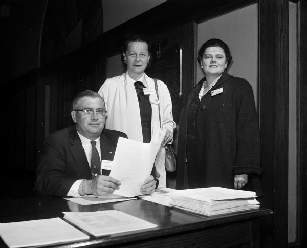Three officials of the Madison Council of Parents and Teachers at the annual school of instruction, left to right, include: Charles Esser, 321 North Brearly Street, council treasurer and chairman of budget and finance; standing, Mrs. Kenneth (Moodie) Brockett, 141 North Franklin Avenue, council yearbook chairman; and Mrs. Elwyn C. (Marion) Pride, 4012 Hiawatha Drive, council chairman of publications and magazines.