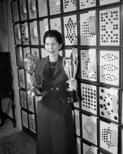 Eunice Quinn poses with her button collection and trophies.