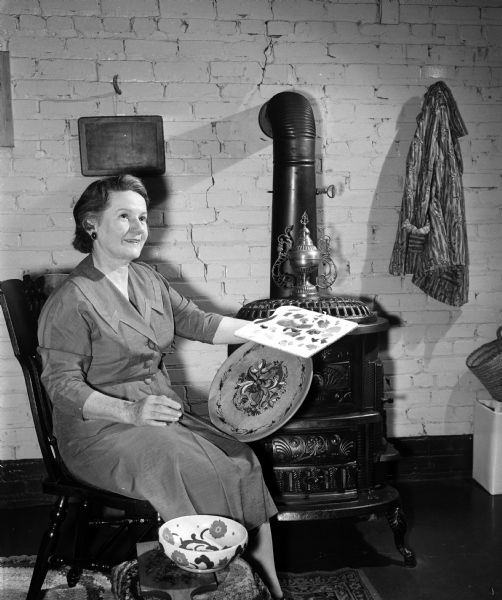 Erdine Stamm is shown rosemalling a wooden plate at the Madison Art Guild workshop in the recreation room of the Brobst home, 211 Lathrop Street.