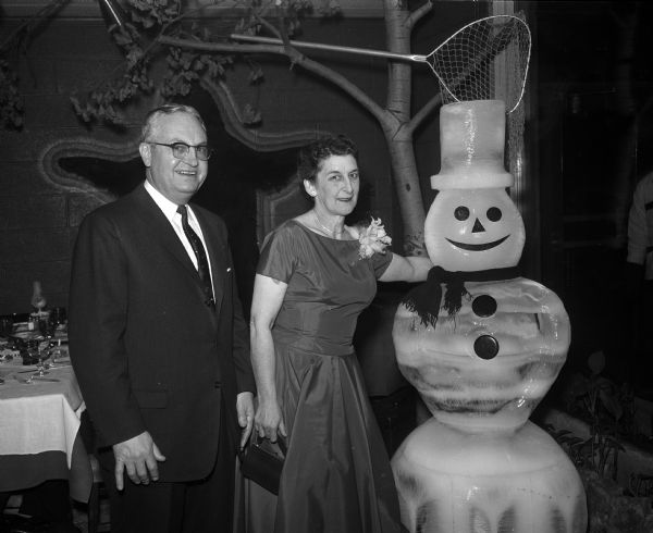 Chairmen of the party Warren and Louise Kreunen admire a full sized snowman decoration at the National Sales Executives of Madison party.