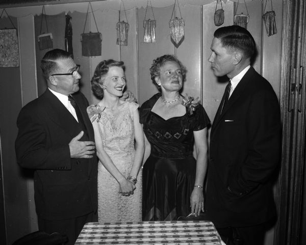Shown chatting at the National Sales Executives of Madison party are: J.A. McIlnay, a member of the national board of directors; Virginia Manzer; Pearl McIlnay; and Harry Manzer Jr., vice-president of the Madison group.
