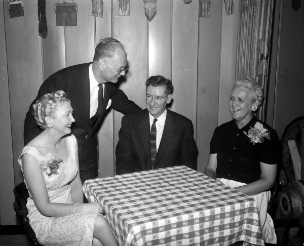 Four guests gathered around a table are: Arletta Duquaine; C.L. Duquaine, past president of the National Sales Executives of Madison; L.E. Dewey; and Mrs. Dewey Dewey, chairman of the sales clinic.