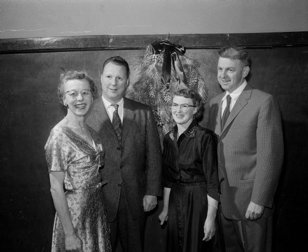 In charge of table  decorations for the Twelfth-Night party at Nakoma School were, at left, Mr. and Mrs. Ralph C. (Tirzah) Parkin of 4149 Mandan Crescent and, at right, Mr. and Mrs. William H. (Margaret) Ferris of 4117 Mandan Crescent.