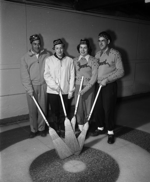 Group portrait of the Bob Harmon rink, the first event champion in the Madison Curling club-sponsored mixed bonspiel. Left to right are Bob and Millie Harmon, and Phyllis and Bill Hustedt.