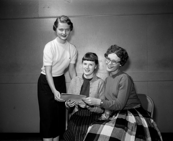 Portrait of three West High School teenagers who are part of a planning committee for a Teens Against Polio dance. Left to right: Kay Johnson, Sally Canfield and Leeta McCoy.