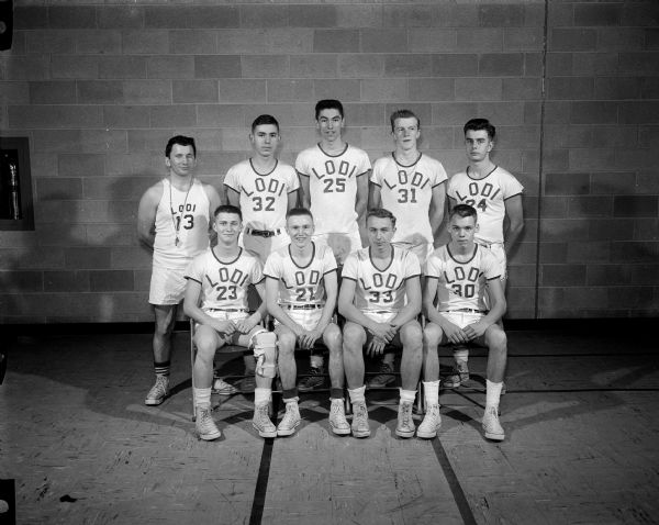 A group portrait of the Lodi High School basketball team. In the front row from left to right are James Miller, Philip Wildt, Willard Johnson, and William Dushek. In the back row from left to right are coach Paul Rosendick, Ronald Kohn, Dale Meade, Philip Gruendemann, and Richard Larson.