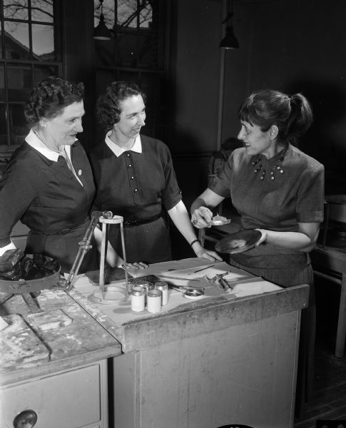 Mrs. Annaliese Steppart, new member of the faculty at Madison Vocational and Adult Education School, demonstrates enameling to two of her students in a jewelry-making class. Left to right are Mrs. L.W. (Gladys) Parr, 4235 Wanda Place, Mrs. William (Marie) Healy, 3806 Manitou Way and Mrs. Steppart.
