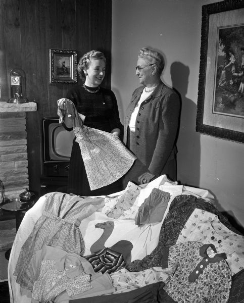 Harriet Langsdorf and Nellie Westmont of the Antioch temple, Daughters of the Nile, admire some of the sewing which members have made for the Shrine Hospital for Crippled Children in Greenville, South Carolina.