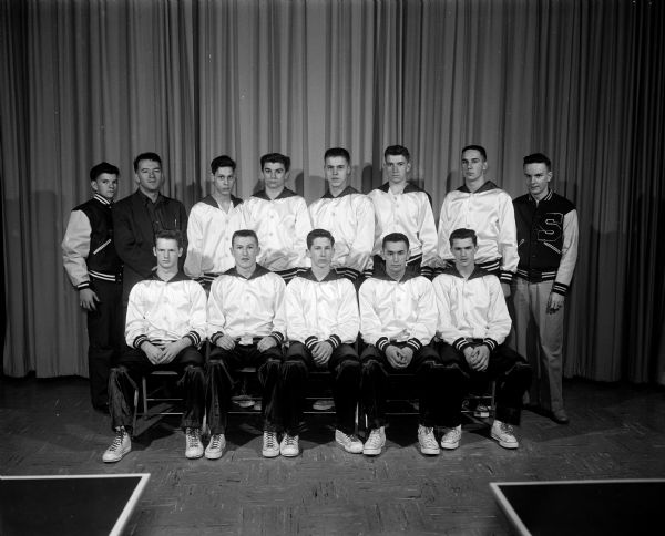 Group portrait of Sauk City High School's basketball team and coach. Front row, left to right: Red Preston, Jack Walsh, Stan Frosch, Larry Breunig, Don Higgins. Back row:  Coach Bob Schrader, Ken Fasking, Wayne Schultz, Tom Schmit, Mel Ballweg, Shorty Young.