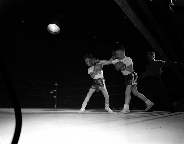 Action shot of two boys boxing. Keith Karow (left) receives a head turning straight right punch to the head sent by Pat McCormick.