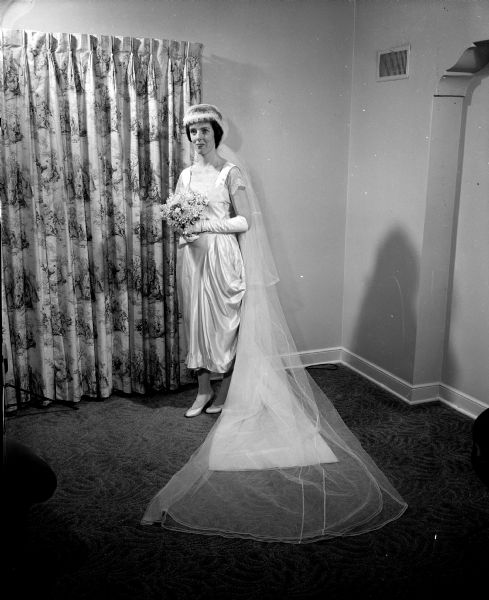 Wedding gowns representing the fashions of 73 years were presented in a bridal show sponsored by the Madison chapter of the Alumnae Association of Edgewood College. Caryl Benish models the gown of ivory satin and imported lace which her mother, the former Stella O'Malley, wore for her marriage on August 31, 1920.