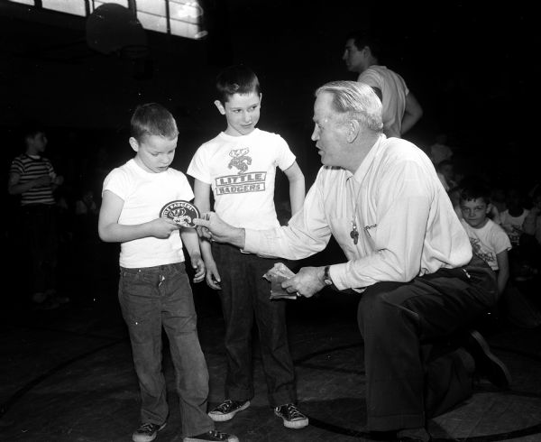 A tournament and a party at St. Bernard's School was held at the end of the 1957 program of Vern Woodward's Little Badger Boxers. Receiving boxing emblems were Pat List, with emblem, and David Koppenhaver, waiting for his emblem. Vern Woodward handed out the awards. Glenn Nording and Bobby Hinds, former University of Wisconsin boxers assisted him with the program.
