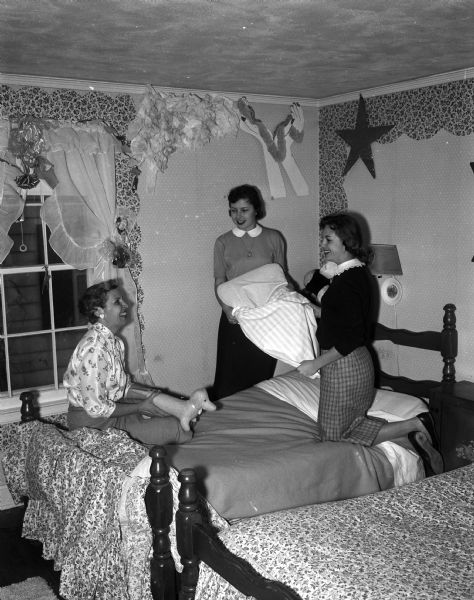 The Brandenburg family is one of hundreds in Madison who open their homes to State Basketball Tournament student guests. Marian Brandenburg and her twin daughters Janet, center, and Jane, right, prepare a bedroom for two of the high school visitors.