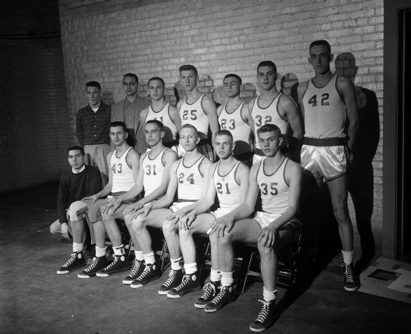 Group portrait of Two Rivers High School boys basketball team. The team is participating in the state high school basketball tournament in the field house located on the University of Wisconsin campus.