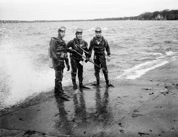 Madison Diving Club members Harold Stitgen, president, Reverend Herbert Schaak, treasurer, and James Filer wearing diving suits and scuba gear, ready for a dive in Lake Mendota off Conklin Park.